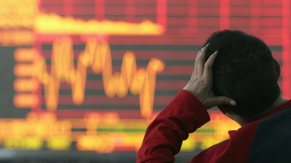 An investor looks at an electronic board showing stock information
