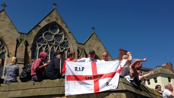 A protester carries a flag beraring the name of Lee Rigby, the British soldier killed in Woolwich
