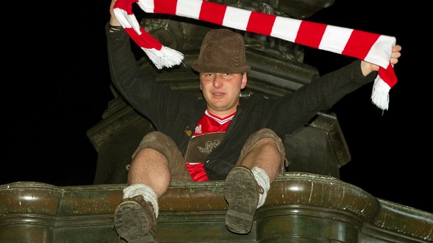 Bayern Munich fan waves a scarf at Piccadilly Circus in London