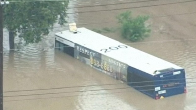A bus is half submerged under the flood water