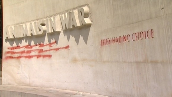 The words on the memorial have been crossed out in red spray paint