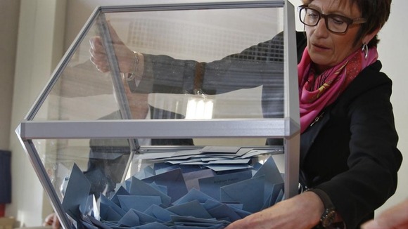 Election official empties a ballot box