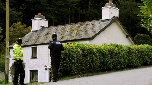 Police outside the cottage Mark Bridger was renting in Ceinws at the time of April's disappearance