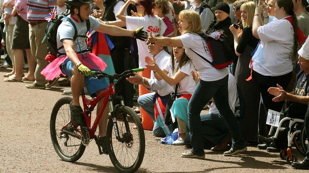 A cyclist gets some support from the waiting crowd.