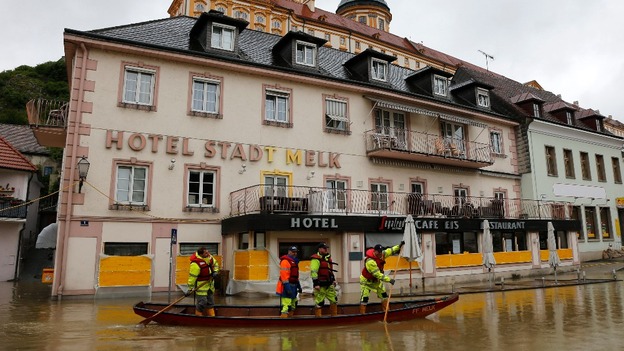 Emergency workers travel by boat along a flooded street in the centre of the Austrian town of Melk