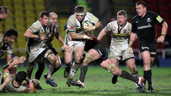Northampton's Alex Waller (centre) is tackled by Saracens Steve Borthwick
