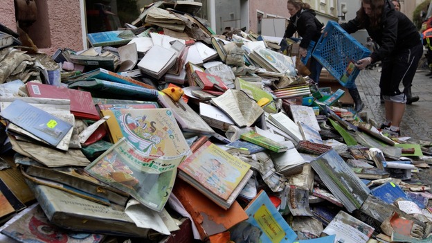 Mud covered books are placed outside a book shop in the town of Passau in Germany