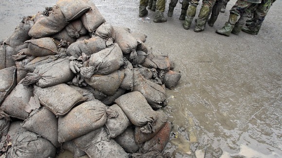Members of the German army stand in the mud next to sandbags in Passau