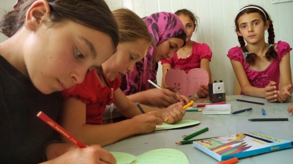 Children drawing in an activity centre at the camp