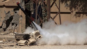 Free Syrian Army fighters react during the firing of a rocket.