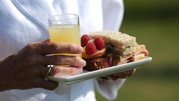 A woman carries sandwiches and cakes
