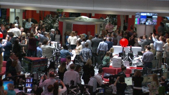 BBC staff get their mobile phones out to take pictures of the Queen during her visit.