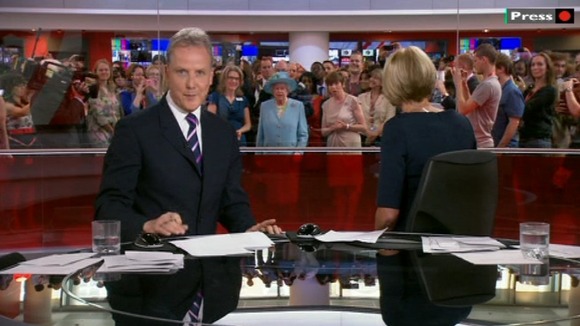 Sophie Long turns around to see the Queen surrounded by a crowd in the newsroom.