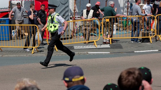 A policeman runs to aid injured spectators at TT 