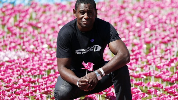 David Harewood planting a flower in a visual petition