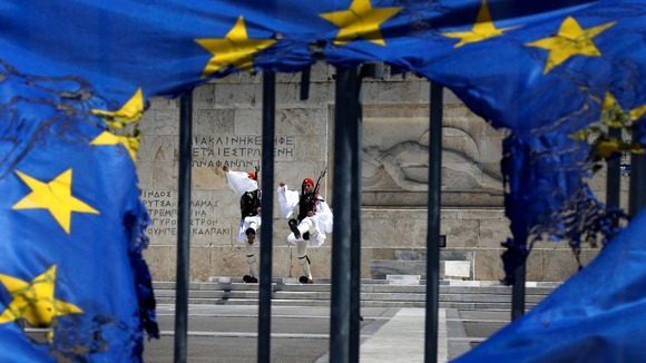 Presidential guards are seen through a burned EU flag in Athens on May Day this year.