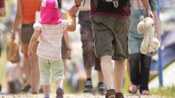 A man holds a child's hand.