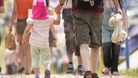 A man holds a child's hand.