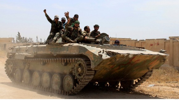 Soldiers loyal to the Syrian regime gesture in the village of Debaa near Qusair earlier this month