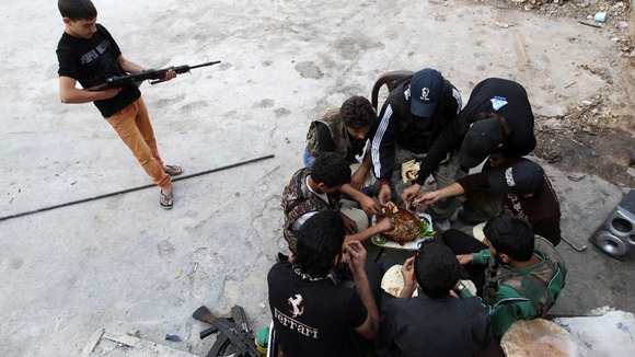 Members of a rebel group eat in a safe house in Aleppo