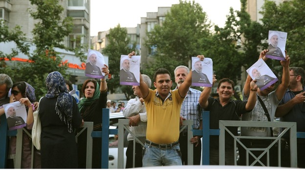 Supporters of Iran's future president, Hassan Rouhani, hold pictures of their man