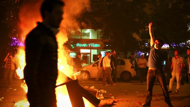 Protesters set fire to a barricade as they clash with riot police in Istanbul.