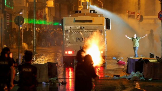 Riot police fire tear gas and a water cannon at Taksim Square in Istanbul.
