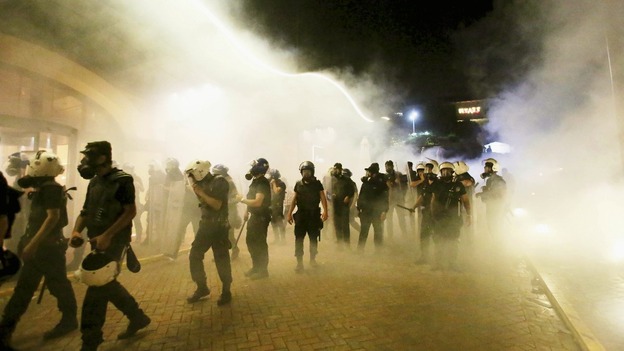 Riot police walk in front of Divan hotel in Istanbul amid a cloud of tear gas.