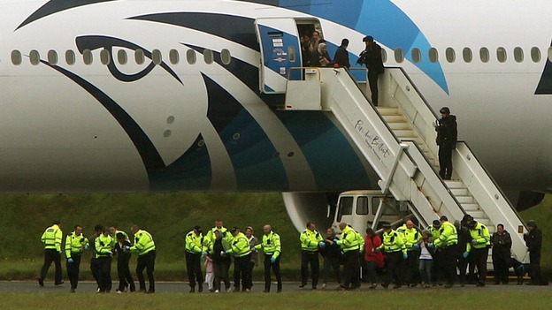 Passengers pictured leaving the Egyptair aircraft yesterday surrounded by police.