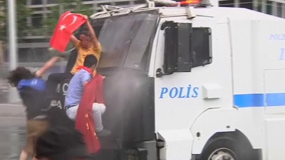 Protesters trying to climb onto a water cannon truck in Istanbul, Turkey