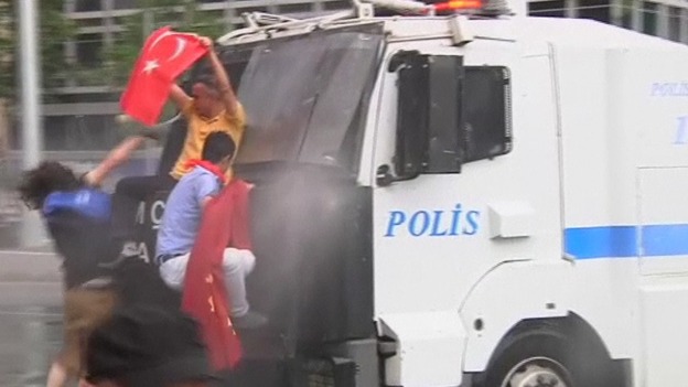 Protesters trying to climb onto a water cannon truck in Istanbul, Turkey