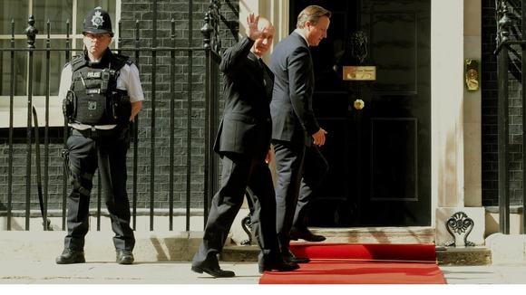Russian President Vladimir Putin waves as he enters Number 10