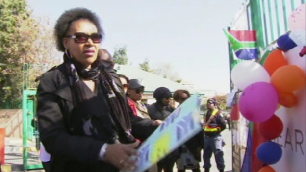 Nelson Mandela's daughter Zenani looks at the tributes left outside the hospital for her father.