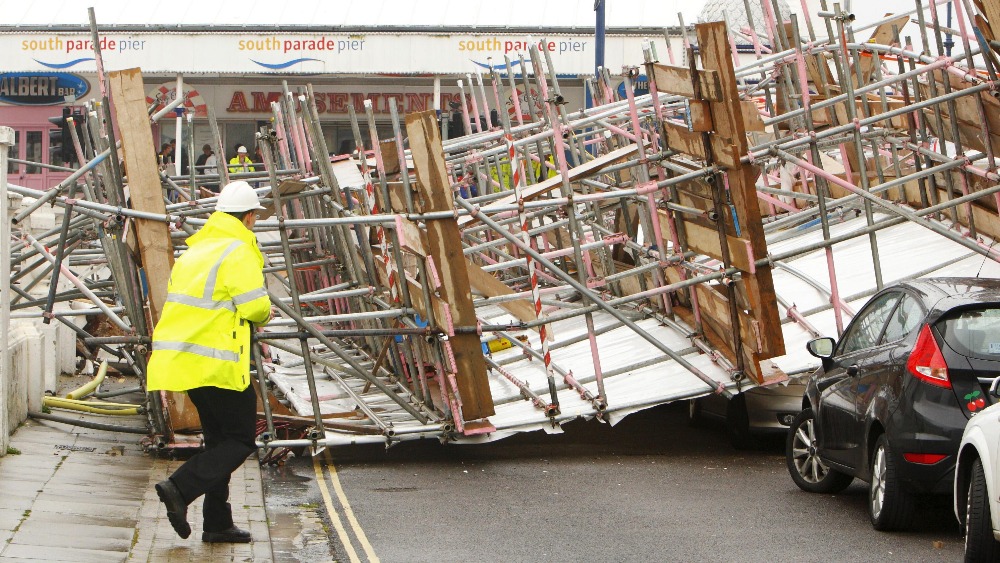 Workers dismantle scaffolding after it collapses in high winds in