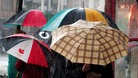 Shoppers use their umbrellas to shield from rain in Straford upon Avon city centre
