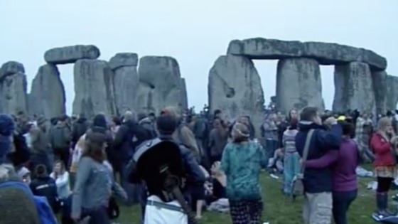 People gather around the stone pillars of Stonehenge