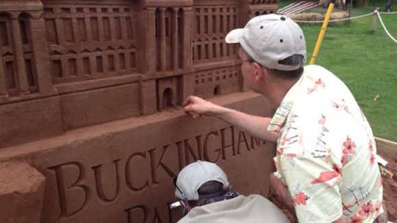 Workers put finishing touches to sandcastles.