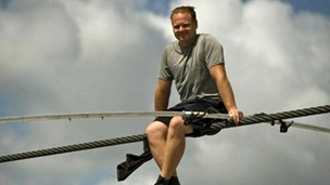 Nik Wallenda sits on the wire he will use to cross Grand Canyon