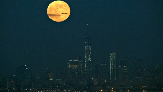The full moon rises above the New York City skyline