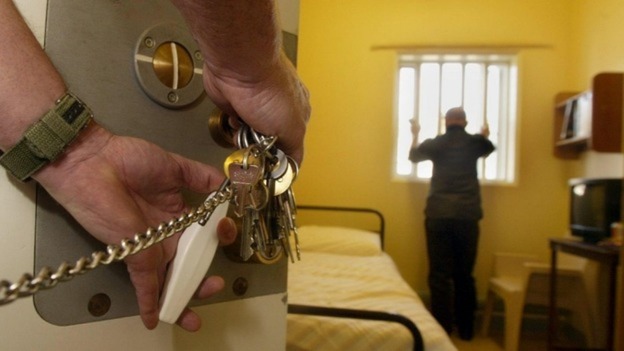 File photo of a prison warden locking a cell door.