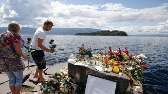 Tributes paid to the dead in Norway with Utoeya island in the background, where the majority of the killings took place.
