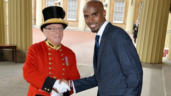 Mo Farah shakes hands with Alan Jenkins as he arrives for investiture ceremony.