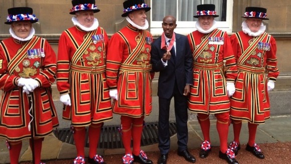 Mo Farah poses with Beefeaters after receiving his CBE.