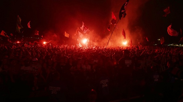 Festival goers watch the Arctic Monkeys performing on the Pyramid Stage