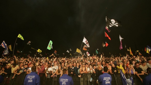 Festival goers watch the Arctic Monkeys performing on the Pyramid Stage