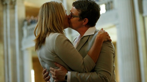 Sandy Stier (L) and Kris Perry kiss after being married