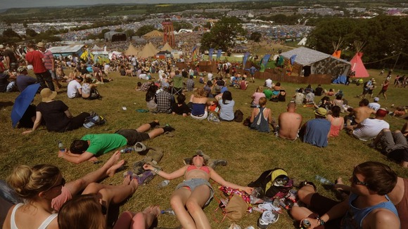 Festival goers enjoy the sunshine at the Glastonbury Festival, at Worthy Farm in Somerset