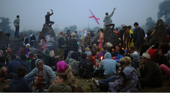 Festival-goers gather in the stone circle at dawn on the final day of the festival