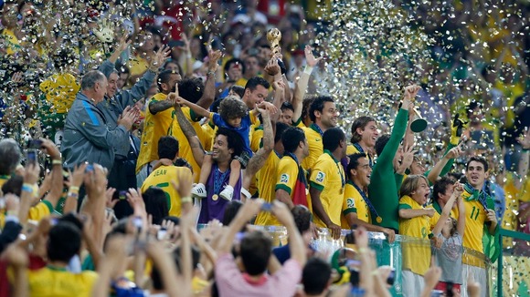 Brazil's players celebrate on the podium with the trophy