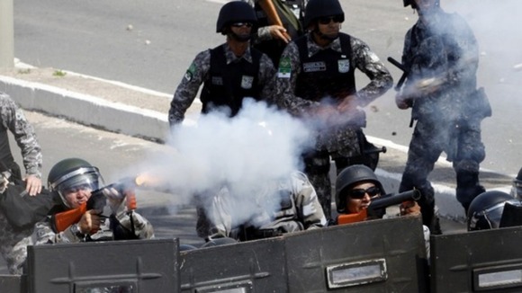 Riot police fire tear gas at protesters near the Estadio Castelao in Fortaleza, CearĂ¡